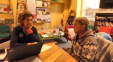 A photo of a South Dartmoor Community Energy advisor talking to a member of the public at a recent drop-in session.